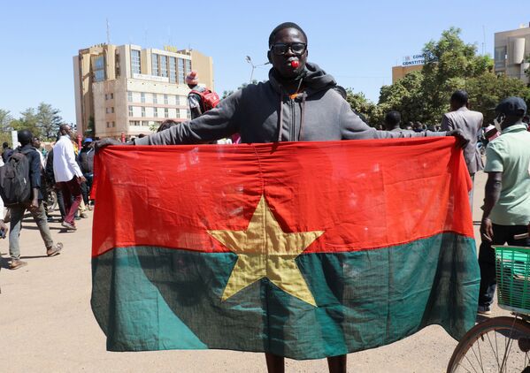 Мужчина держит в руках национальный флаг Буркина-Фасо. - Sputnik Армения