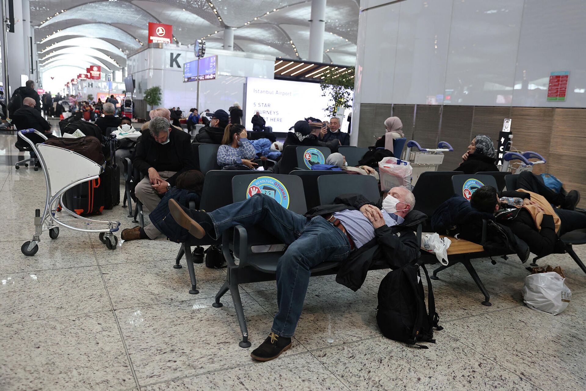 Застрявшие пассажиры ждут своих рейсов в аэропорту Стамбула, который приостанавливает полеты из-за сильного снегопада (25 января 2022). Турция - Sputnik Армения, 1920, 25.01.2022