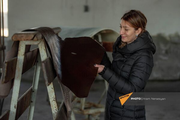 Сотрудница Ереванского кожевенного завода рассматривает готовую продукцию - Sputnik Армения