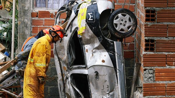 Пожарный и перевернутая машина на месте схода оползня в бразильском штате Сан-Паулу  - Sputnik Армения