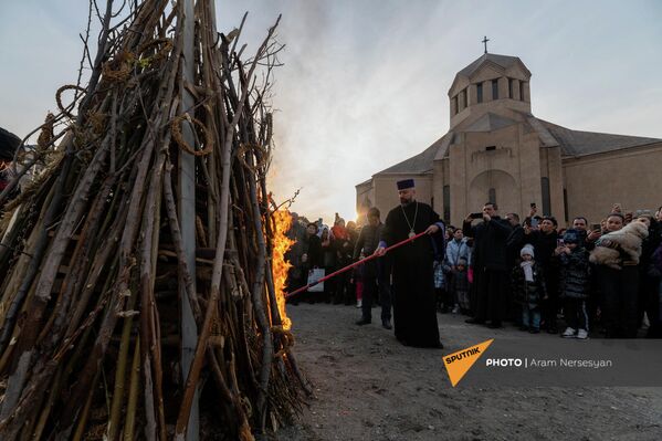 Հոգևորականը վառում է Տրնդեզի կրակը Սուրբ Գրիգոր Լուսավորիչ եկեղեցու բակում  - Sputnik Արմենիա