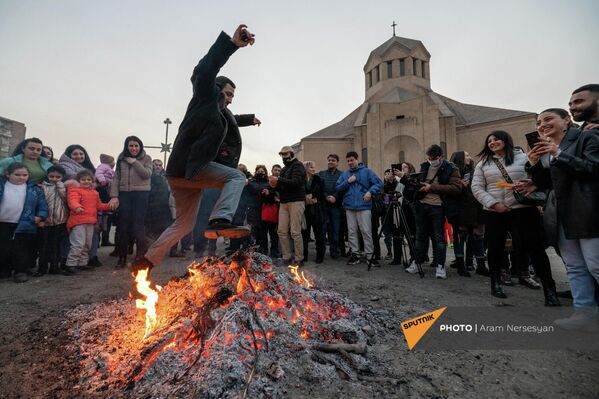 Երիտասարդները ցատկում են Տրնդեզի կրակի վրայով Սուրբ Գրիգոր Լուսավորիչ եկեղեցու բակում (13 փետրվարի, 2022թ). Երևան - Sputnik Արմենիա