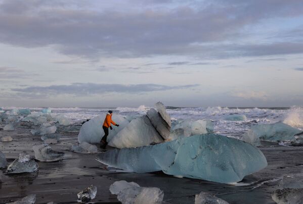 Զբոսաշրջիկն ուսումնասիրում է սառցադաշտային ծովածոցից պոկված սառույցի քարերը - Sputnik Արմենիա