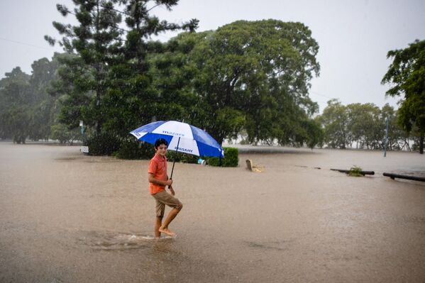 Мальчик с зонтом на затопленной улице в Австралии․ - Sputnik Армения