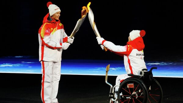 Ма Цзя и Чжан Сюэмэй из Китая передают Паралимпийский огонь во время церемонии открытия Паралимпиады (4 марта 2022). Пекин - Sputnik Армения