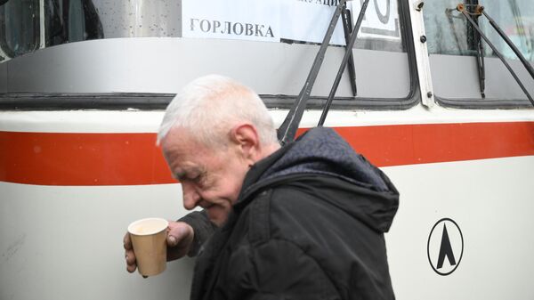 Мужчина стоит возле автобуса во время эвакуации из Горловки на территорию России - Sputnik Армения
