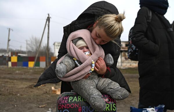 Մայրը փոքր երեխայի հետ գնում է դեպի Ռոստովի մարզ ուղևորվող ավտոբուսը - Sputnik Արմենիա