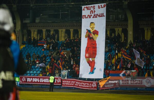Баннер с изображением Генриха Мхитаряна на трибуне во время товарищеского матча по футболу между сборными Армении и Черногории (24 марта 2022). Ереван - Sputnik Армения