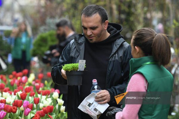 Տղամարդը ծաղիկ է ընտրում «Գարնանային այգի» ծաղկի և բույսերի տոնավաճառից - Sputnik Արմենիա