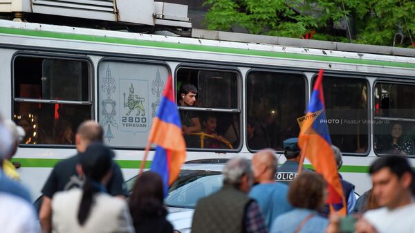 Пассажир троллейбуса наблюдает за маршем осведомленности Проснись, Лао (27 апреля 2022). Еревaн - Sputnik Армения