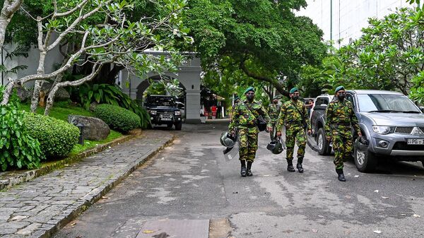 Сотрудники службы безопасности Шри-Ланки входят в официальную резиденцию уходящего премьер-министра Махинды Раджапаксы (10 мая 2022). Коломбо - Sputnik Армения