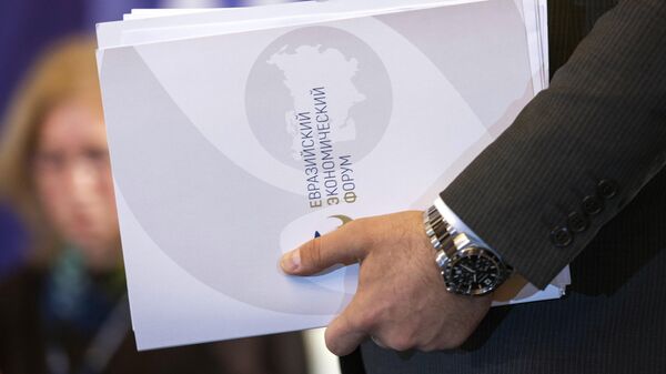 Брошюры с символикой Евразийского экономического форума в руках участника (26 мая 2022). Бишкек - Sputnik Армения