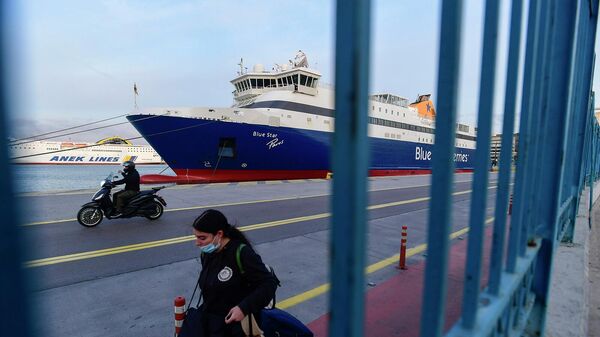 Пассажир проходит мимо пришвартованного корабля в порту Пирей в Греции - Sputnik Армения