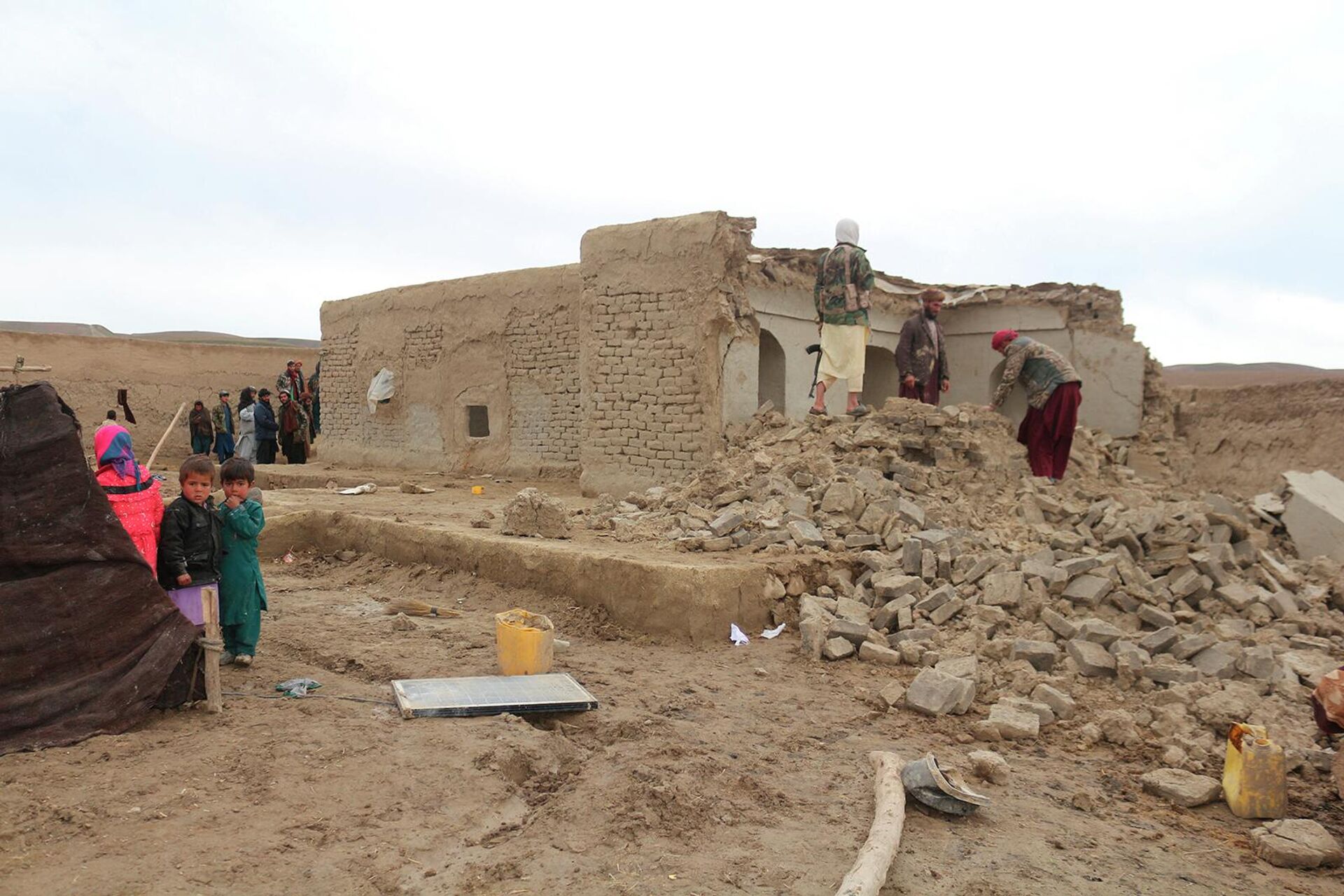 Жители возле разрушенного землетрясением дома в районе Кадис в южной части провинции Бадгис (18 января 2018). Афганистан - Sputnik Արմենիա, 1920, 22.06.2022