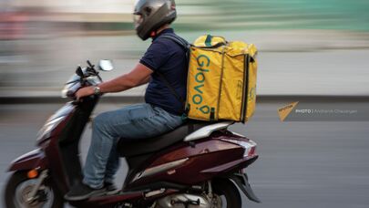 Сотрудник службы доставки на мопеде