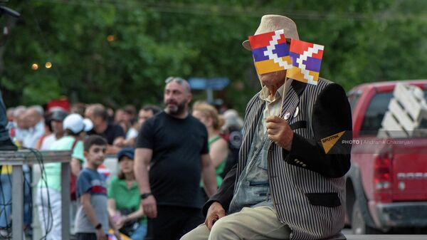 Пожилой человек с флагами Арцаха на митинге оппозиции в рамках акции Сопротивление на площади Франции (1 июля 2022). Еревaн - Sputnik Армения