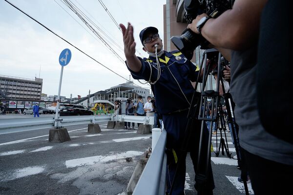 Ոստիկանական սպան փորձում է ԶԼՄ–ների ներկայացուցիչներին դուրս բերել այն շրջանից, որտեղ կրակել են Ճապոնիայի նախկին վարչապետի վրա - Sputnik Արմենիա