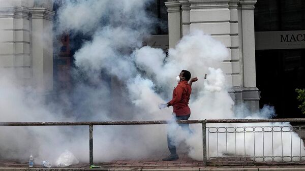 Протестующий бросает баллончик со слезоточивым газом во время столкновения с полицией в Коломбо (9 июля 2022). Шри-Ланка - Sputnik Армения