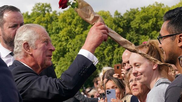 Люди дарят розу королю Великобритании Карлу III у Букингемского дворца после смерти королевы Елизаветы II (9 сентября 2022). Лондон - Sputnik Армения