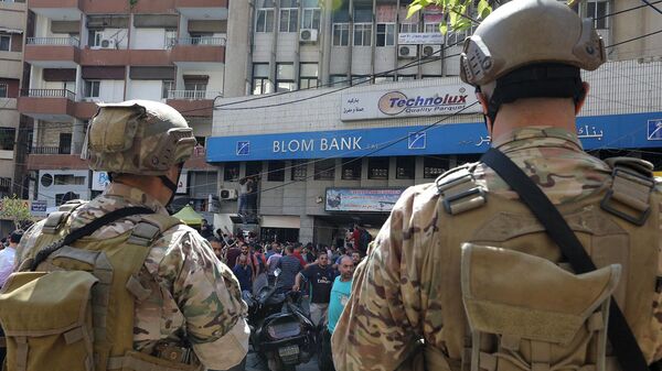 Сотрудники ливанских спецслужб у отделения Blom Bank, куда собираются люди с поддержкой ворвавшегося в банк вкладчика, требующего вывести его замороженные сбережения (16 сентября 2022). Бейрут - Sputnik Армения