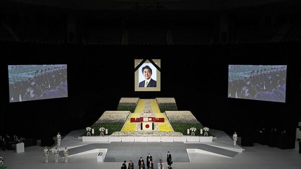 Портрет бывшего премьер-министра Японии Синдзо Абэ висит над сценой во время его государственных похорон в Ниппон Будокан (27 сентября 2022). Токио - Sputnik Армения