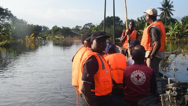 Представители Красного Креста и Национального агентства по чрезвычайным ситуациям (NEMA) ищут нуждающихся в помощи жителей общины Ула-Иката, затопленных наводнением в районе Ахоада штата Риверс (28 октября 2022). Нигерия - Sputnik Армения