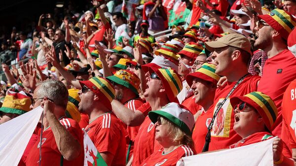 Болельщики Уэльса поют национальный гимн в начале футбольного матча группы B чемпионата мира по футболу 2022 года в Катаре между Уэльсом и Ираном на стадионе Ахмада бин Али (25 ноября 2022). Аль-Райян - Sputnik Армения