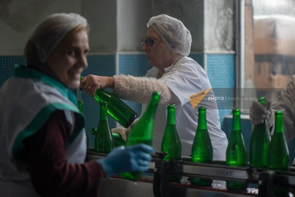 Работники Ереванского завода шампанских вин вручную доливают спиртное в бутылки в цехе по розливу вин - Sputnik Армения