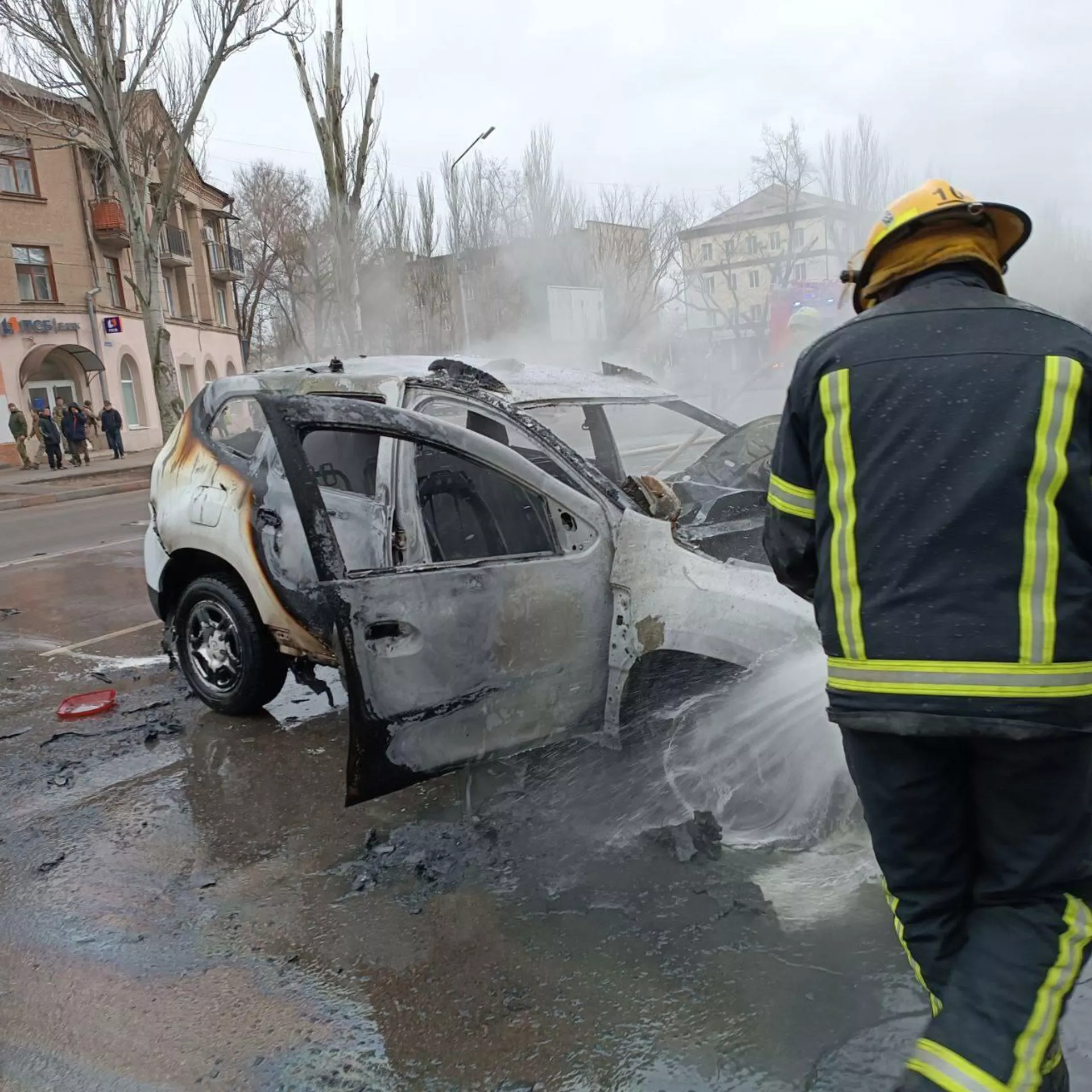 Пожарник тушит взорвавшийся автомобиль перед входом в парк Горького (23 декабря 2022). Мелитополь - Sputnik Армения, 1920, 23.12.2022