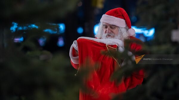 Мужчина в костюме Санты Клауса на Рождественской ярмарке в парке 2750-летия Еревана (3 января 2023). Еревaн - Sputnik Армения