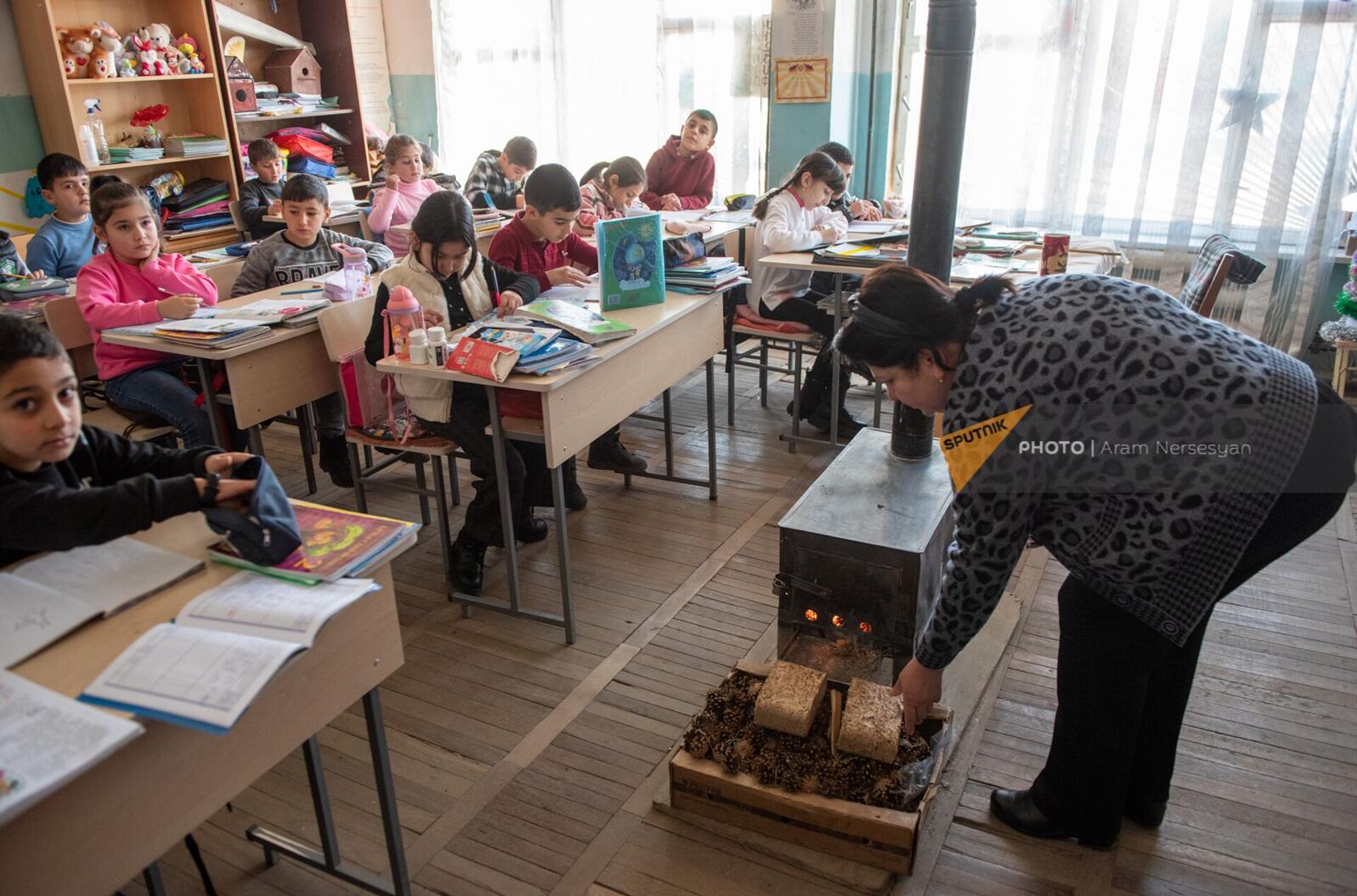 Учительница у дровяной печки в классной комнате в школе №3 общины Норатус - Sputnik Армения, 1920, 30.01.2023