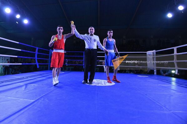 Рефери объявляет победителем Генрика Саакяна по окончании боя против Роберта Хандояна (54 кг) на чемпионате Армении по боксу среди мужчин (31 января 2023). Еревaн - Sputnik Армения