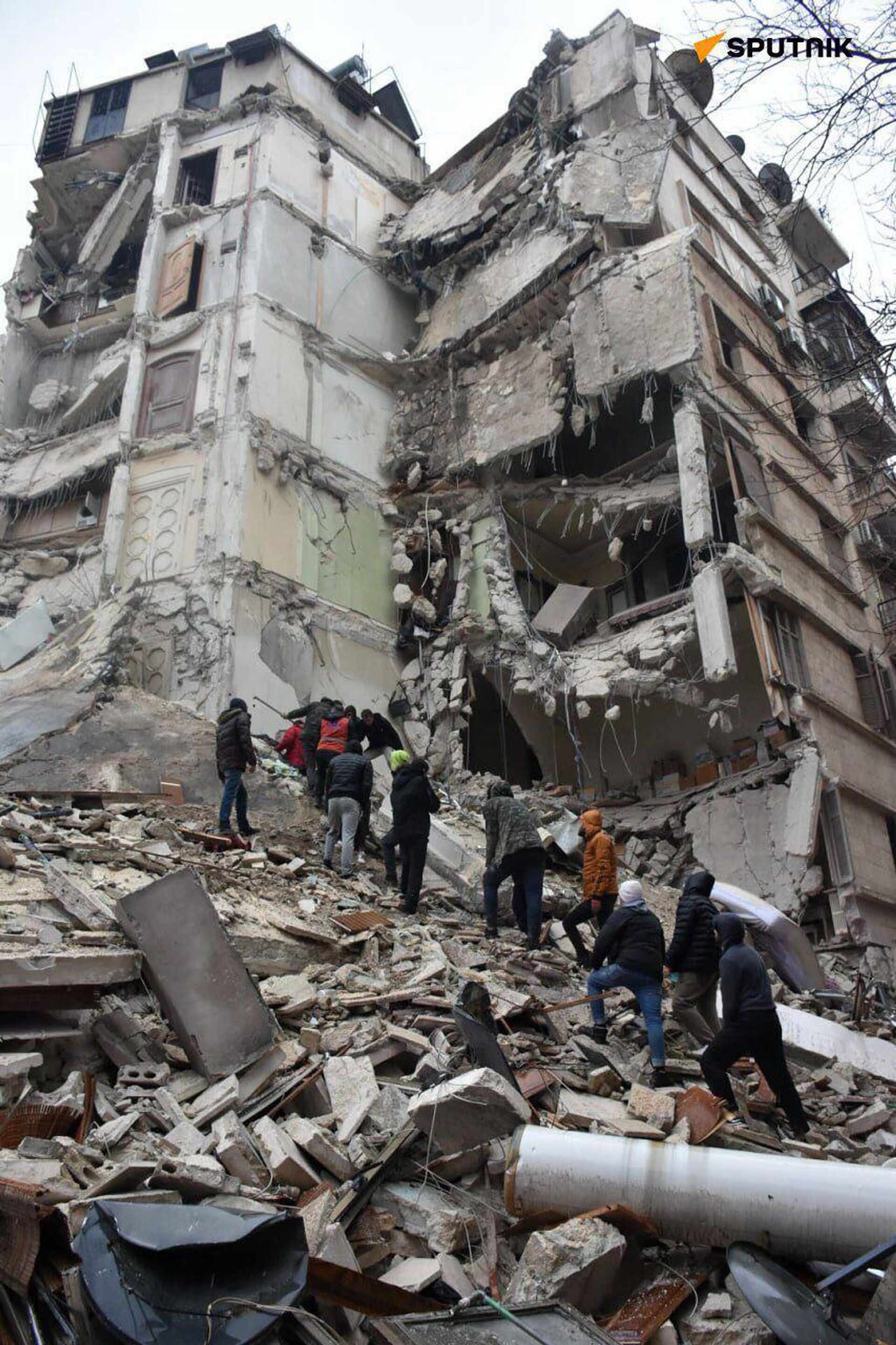 Сирийские спасатели и гражданские лица ищут жертв и выживших среди обломков рухнувшего из-за землетрясения здания (6 февраля 2023). Алеппо - Sputnik Արմենիա, 1920, 20.02.2023