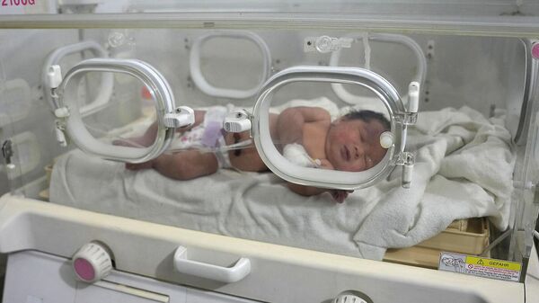 Новорожденный ребенок, который был найден все еще связанным пуповиной со своей матерью и извлечен живым из-под обломков дома после смертельного землетрясения (7 февраля 2023). Сирия - Sputnik Армения