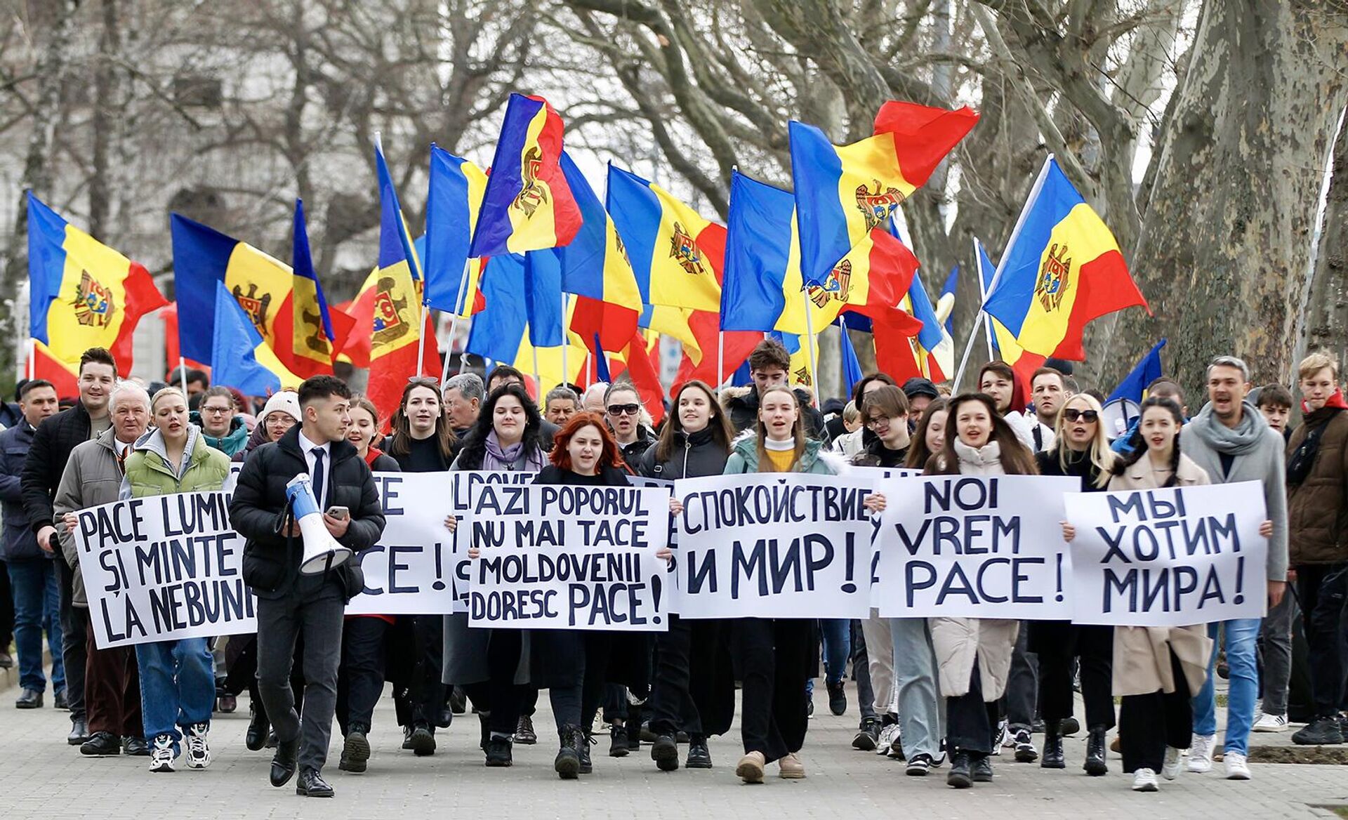 Участники акции оппозиции За мир проходят с плакатами и флагами по центру молдавской столицы (25 февраля 2023). Кишинев - Sputnik Армения, 1920, 25.02.2023