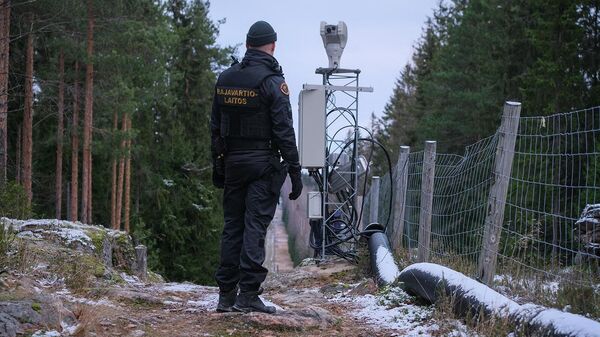 Офицер пограничной службы Финляндии стоит вдоль забора, обозначающего границу между Финляндией и Российской Федерацией - Sputnik Армения