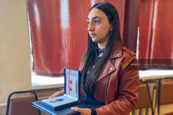 Сестра погибшего в результате азербайджанской агрессии 13-15 сентября 2022 года солдата-срочника Карена Карапетяна Нуне с посмертной наградой брата (29 марта 2023). Гюмри - Sputnik Армения