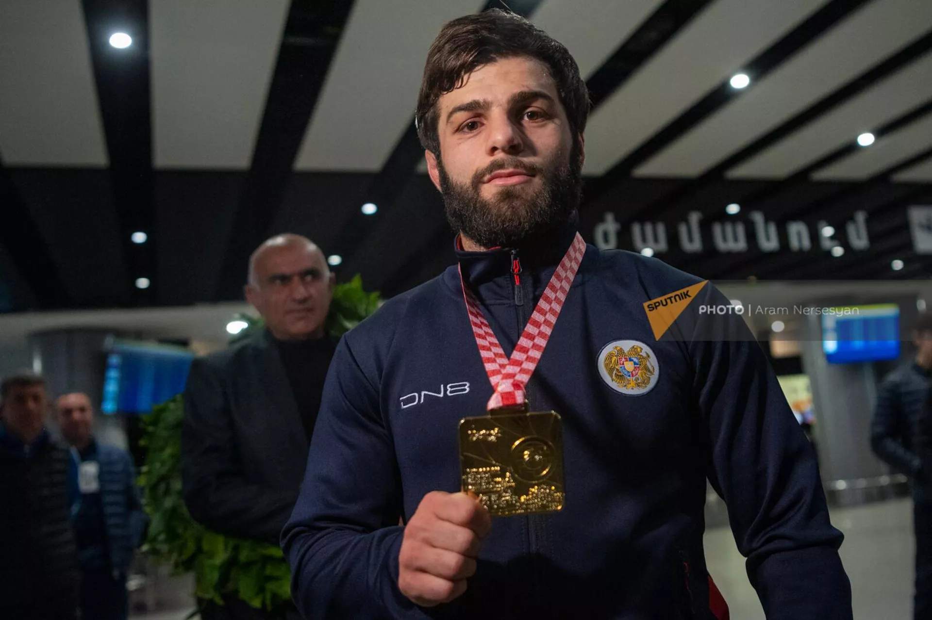 Чемпион Европы по вольной борьбе Вазген Теванян  показывает свою золотую медаль в аэропорту Звартноц по возвращении на родину (21 апреля 2023). Еревaн - Sputnik Армения, 1920, 21.04.2023