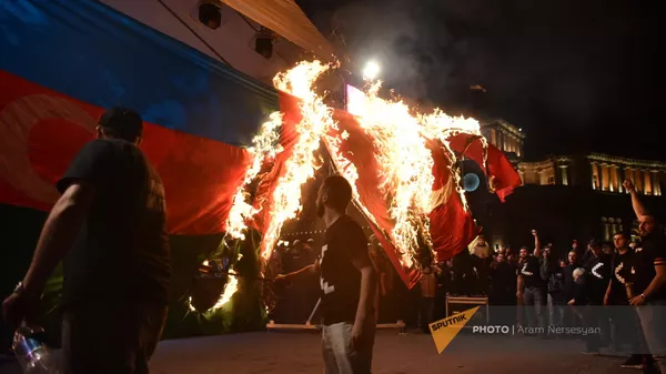 Участники факельного шествия традиционно сжигают флаги Азербайджана и Турции (23 апреля 2023). Еревaн - Sputnik Армения