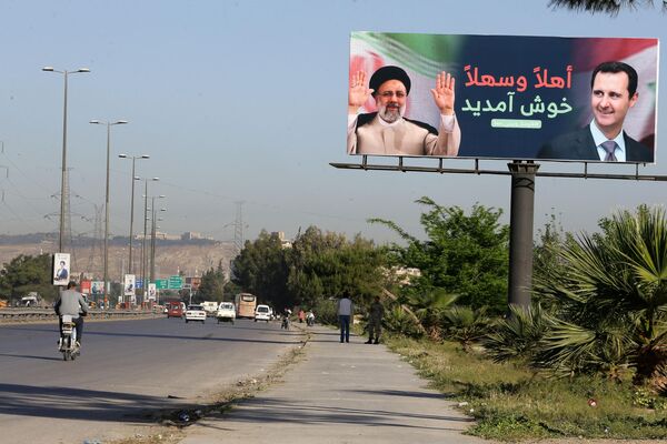 Рекламный щит с фотографиями президентов Ирана и Сирии Ибрахима Раиси и Башара Асада стоит на дороге, ведущей к международному аэропорту Дамаска - Sputnik Армения