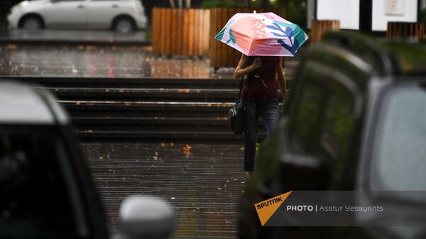 Женщина с зонтиком под дождем на одной улиц в Ереване - Sputnik Армения