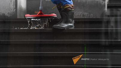 Уборщица в дождливый день моет лестницы подземного перехода на проспекте Маштоца