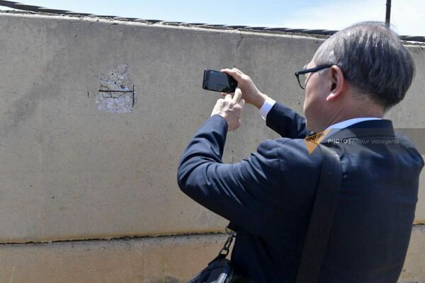Посол Японии в Армении Фукусима Масанори фотографирует пулевое отверстие.  - Sputnik Армения