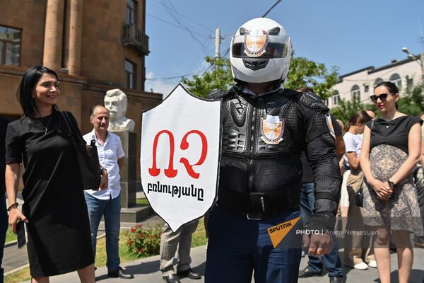 Участник акции протеста адвокатов в стилизованном костюме с надписью Нет насилию на щите (20 июня 2023). Ереван - Sputnik Армения
