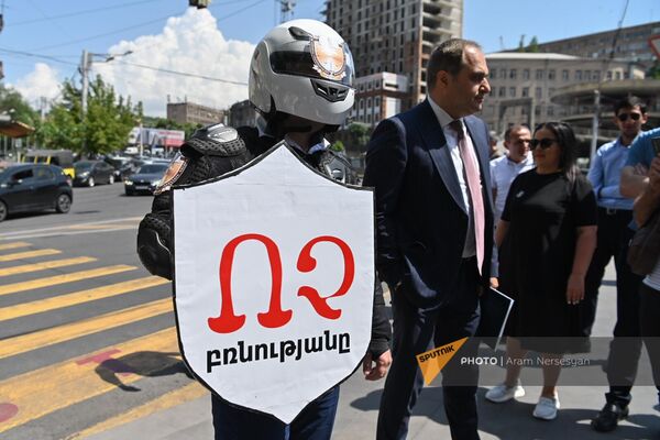 Участник акции протеста адвокатов в стилизованном костюме с надписью Нет насилию на щите (20 июня 2023). Ереван - Sputnik Армения