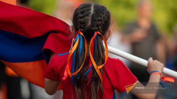 Маленькая участница традиционного шествия в честь Дня Конституции и государственных символов с армянским триколором (5 июля 2023). Еревaн - Sputnik Армения