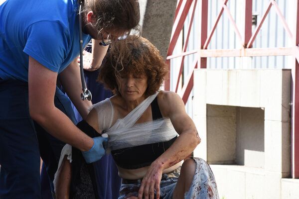 Медицинский сотрудник оказывает помощь женщине, раненной в результате обстрела Донецка со стороны ВСУ (31 июля 2023). Донецк - Sputnik Армения