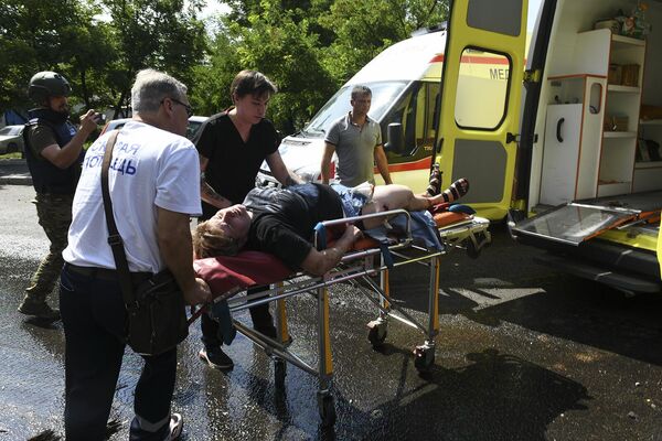 Люди кладут на носилки женщину, раненного в результате обстрела Донецка со стороны ВСУ (31 июля 2023). Донецк - Sputnik Армения