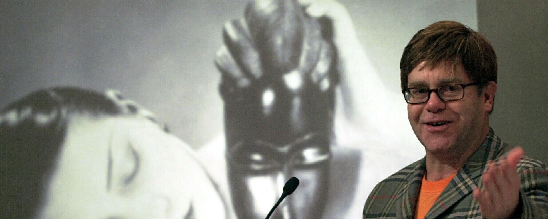 Элтон Джон стоит перед картиной Мана Рэя Noire et Blanche во время пресс-конференции в Нью-Йорке, США - Sputnik Армения, 1920, 19.08.2023