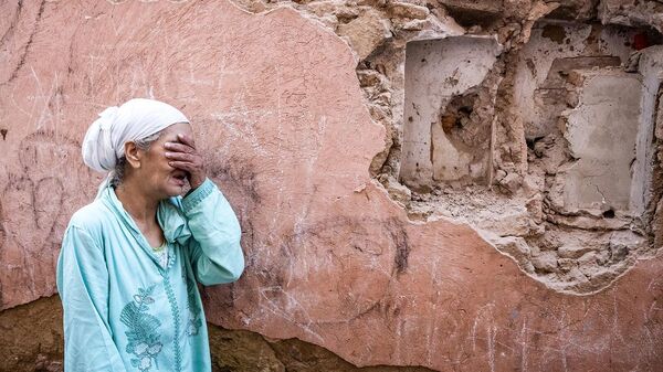 Женщина плачет у своего разрушенного землетрясением дома (9 сентября 2023). Марокко - Sputnik Армения